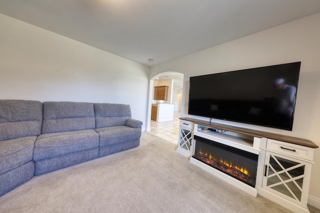 24500 Jacaranda Dr, Tehachapi, CA 93561 - living area featuring arched walkways, light colored carpet, and a glass covered fireplace