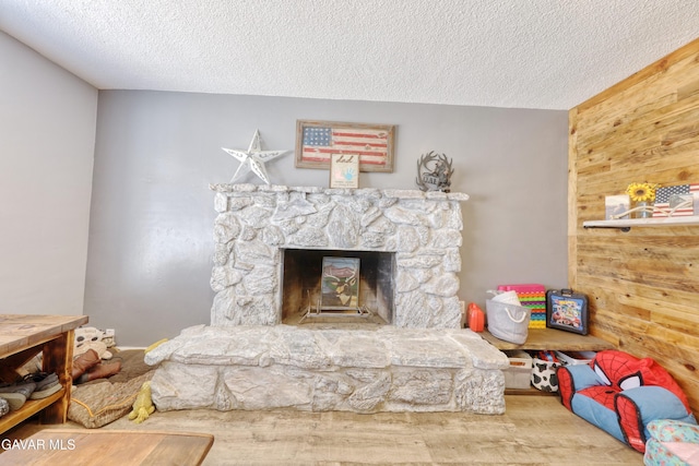 20412 El Porto Ct, Tehachapi, CA 93561 - living area featuring wood finished floors, a textured ceiling, a fireplace, and wood walls