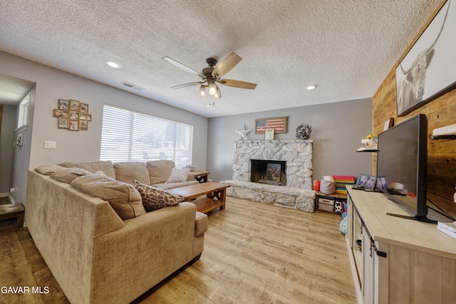 20412 El Porto Ct, Tehachapi, CA 93561 - living room with ceiling fan, a stone fireplace, wood finished floors, a textured ceiling, and recessed lighting