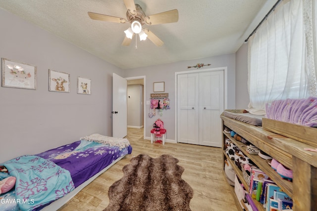 20412 El Porto Ct, Tehachapi, CA 93561 - bedroom with light wood-style flooring, a textured ceiling, a closet, and a ceiling fan