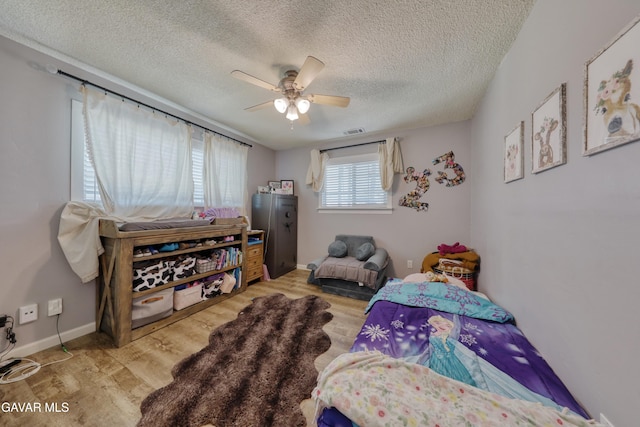 20412 El Porto Ct, Tehachapi, CA 93561 - bedroom featuring light wood-style floors, a textured ceiling, and a ceiling fan