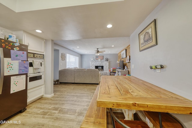 20412 El Porto Ct, Tehachapi, CA 93561 - dining area with light wood finished floors, a stone fireplace, ceiling fan, and recessed lighting