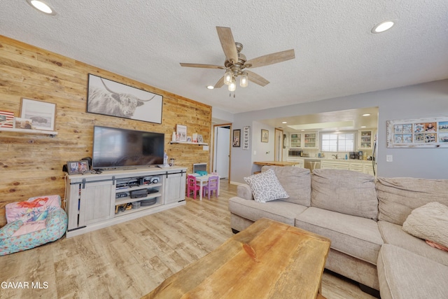 20412 El Porto Ct, Tehachapi, CA 93561 - living area with wood walls, ceiling fan, a textured ceiling, light wood-type flooring, and recessed lighting