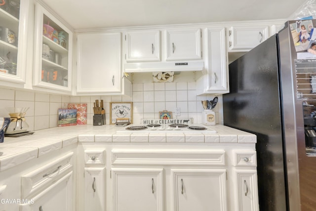 20412 El Porto Ct, Tehachapi, CA 93561 - kitchen with freestanding refrigerator, white cabinets, tile counters, and backsplash