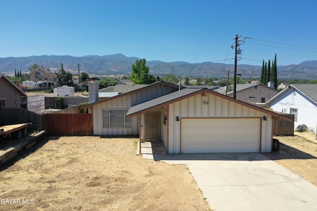 20412 El Porto Ct, Tehachapi, CA 93561 - view of front of home with a garage, driveway, a mountain view, and board and batten siding