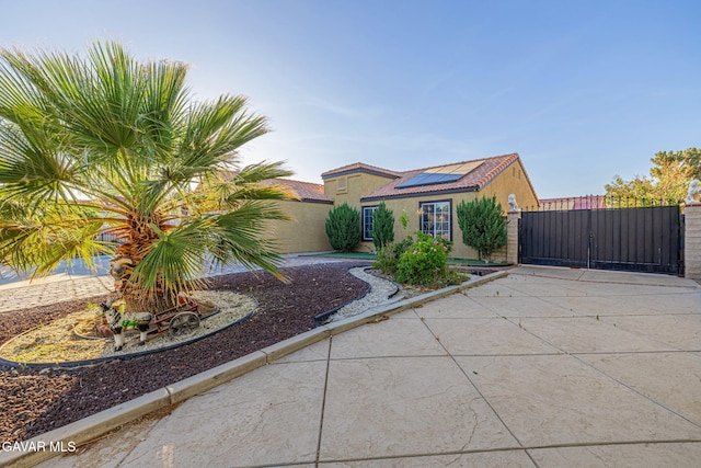 6019 Diamond St, Palmdale, CA 93552 - view of front of house featuring a gate, solar panels, and stucco siding