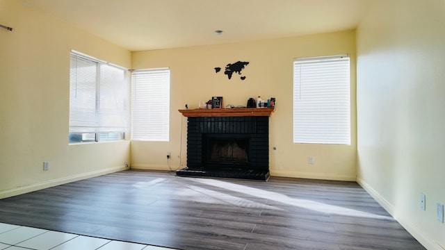 unfurnished living room with hardwood / wood-style floors, plenty of natural light, and a fireplace