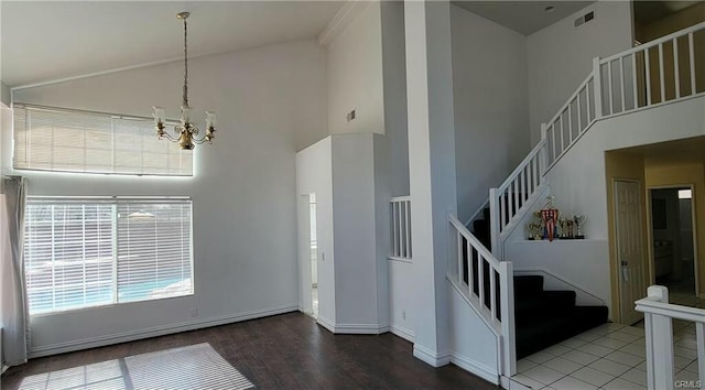 interior space featuring tile patterned floors, high vaulted ceiling, and an inviting chandelier