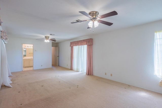empty room featuring visible vents, ceiling fan, and light carpet