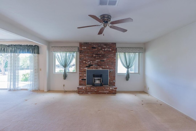 unfurnished living room with a ceiling fan, visible vents, carpet, and a wood stove