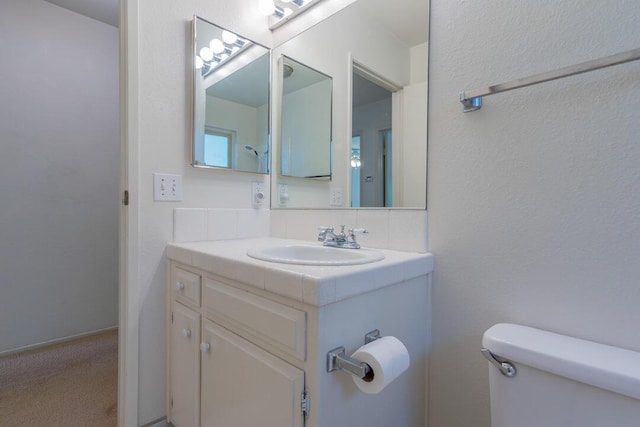 half bathroom featuring vanity and toilet