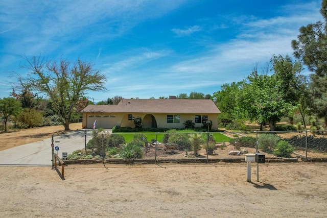ranch-style home featuring a garage, a fenced front yard, stucco siding, and driveway