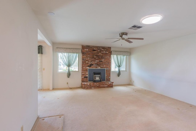 unfurnished living room with a healthy amount of sunlight, carpet floors, ceiling fan, and visible vents