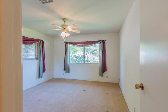 carpeted empty room with ceiling fan and visible vents