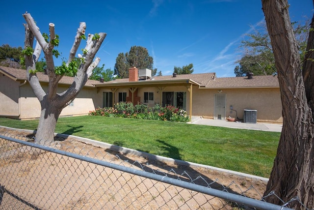 view of front of house featuring fence, stucco siding, a chimney, and a front yard