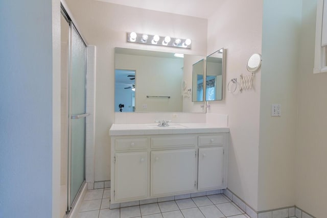 full bathroom featuring ceiling fan, a shower stall, vanity, tile patterned floors, and baseboards