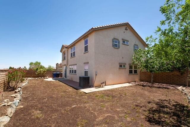2447 Brompton Ct, Palmdale, CA 93551 - rear view of house with stucco siding, a fenced backyard, and central AC unit