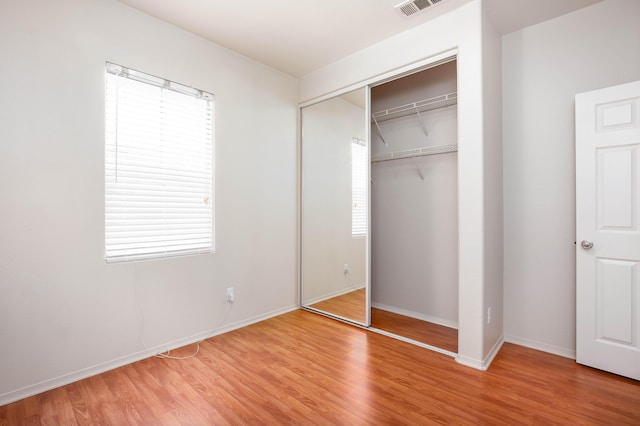 2447 Brompton Ct, Palmdale, CA 93551 - unfurnished bedroom with light wood finished floors, a closet, baseboards, and multiple windows