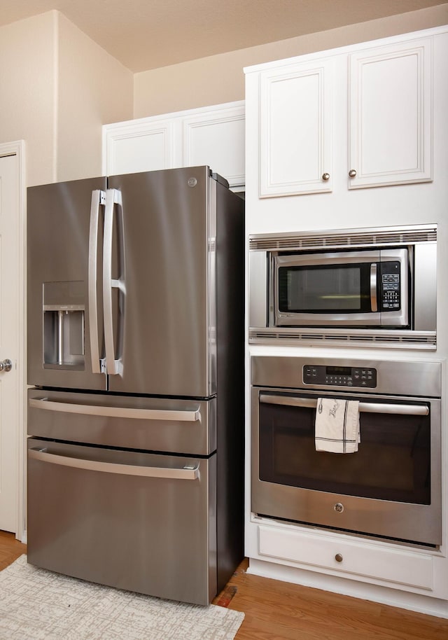 2447 Brompton Ct, Palmdale, CA 93551 - kitchen featuring appliances with stainless steel finishes, white cabinetry, and wood finished floors