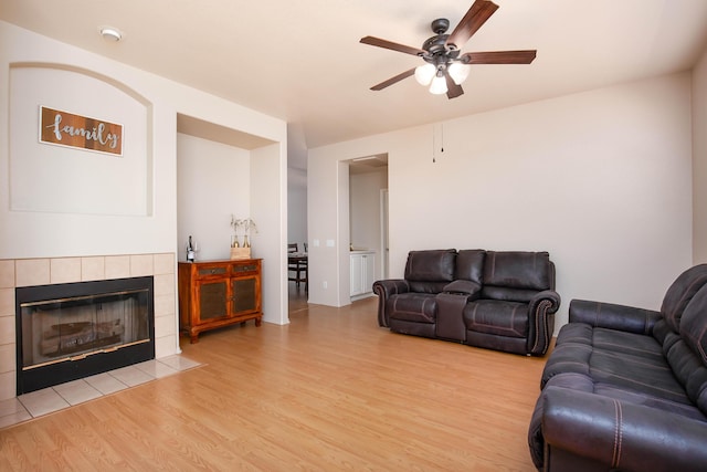 2447 Brompton Ct, Palmdale, CA 93551 - living room with light wood-style floors, ceiling fan, and a tile fireplace
