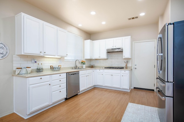 2447 Brompton Ct, Palmdale, CA 93551 - kitchen with stainless steel appliances, under cabinet range hood, a sink, light wood-style floors, and recessed lighting