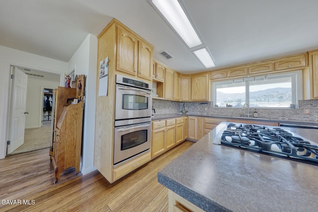 19426 Cavalier Ct, Tehachapi, CA 93561 - kitchen featuring light brown cabinets, double oven, light wood-type flooring, and gas stovetop
