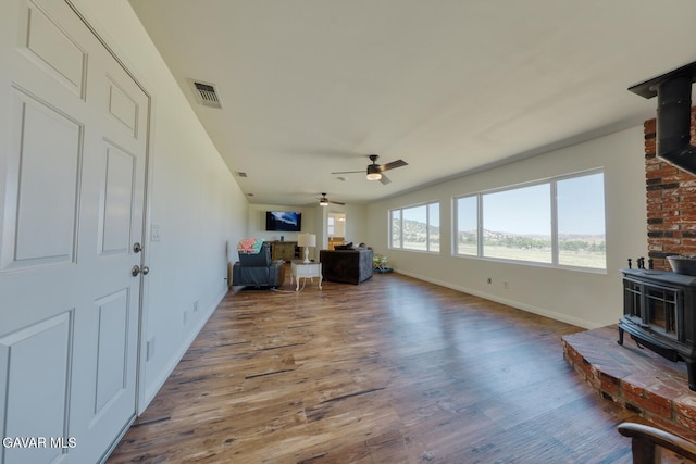 19426 Cavalier Ct, Tehachapi, CA 93561 - living room with a wood stove, a ceiling fan, and wood finished floors