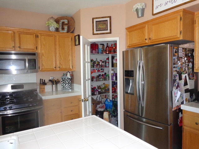 kitchen featuring stainless steel appliances and tile countertops