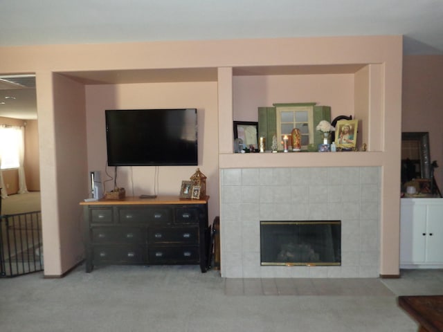 carpeted living room with a tiled fireplace