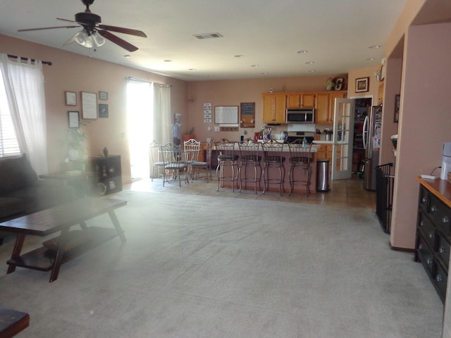 living room with ceiling fan and light carpet