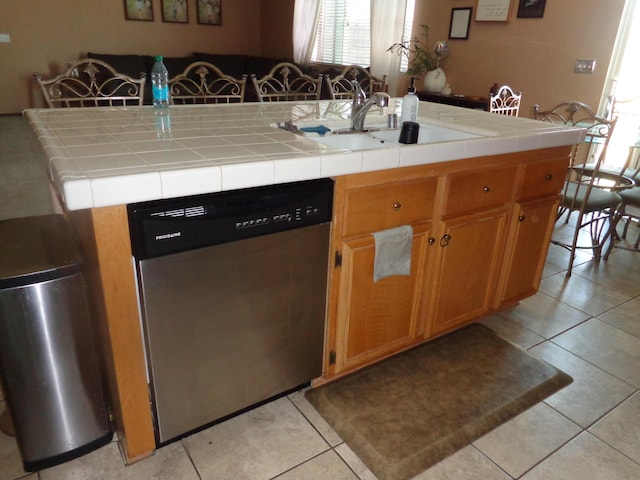 kitchen with sink, light tile patterned floors, tile countertops, and stainless steel dishwasher