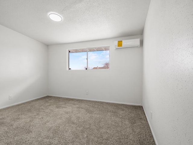 carpeted empty room featuring a textured wall, baseboards, a textured ceiling, and a wall mounted AC