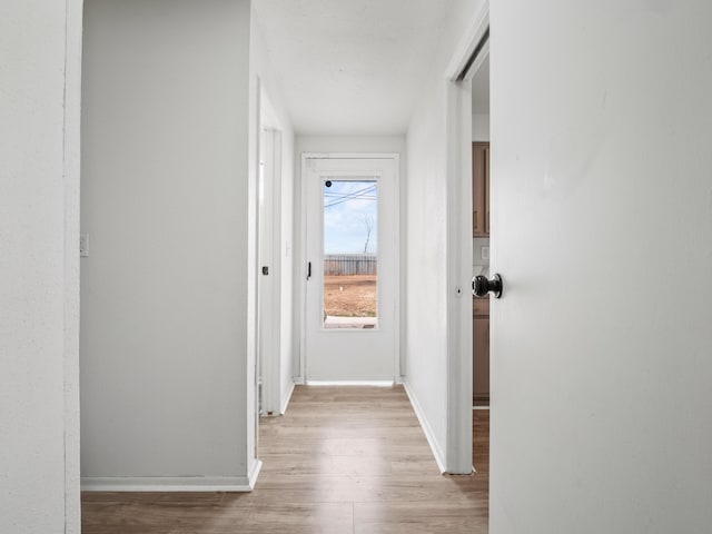 hallway with baseboards and light wood-type flooring