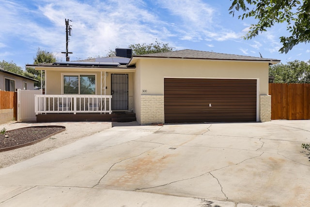 300 W W Ave J9, Lancaster, CA 93534 - view of front facade featuring stucco siding, a garage, concrete driveway, solar panels, and a porch