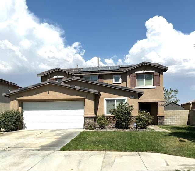 view of front facade featuring a garage, a front lawn, and solar panels