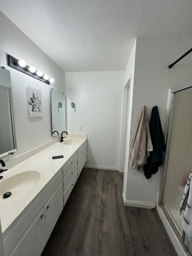 bathroom with walk in shower, vanity, a textured ceiling, and hardwood / wood-style flooring