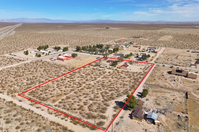 drone / aerial view with view of desert and a mountain view