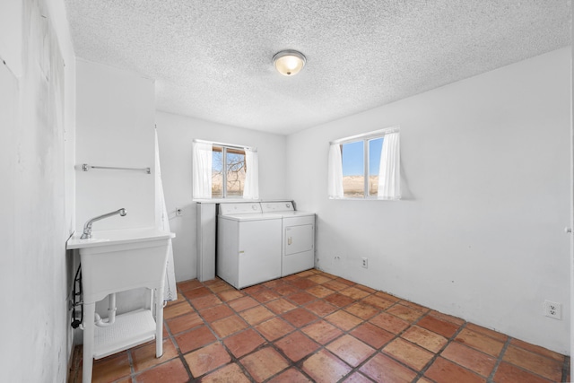 laundry room featuring laundry area, a textured ceiling, and washing machine and clothes dryer