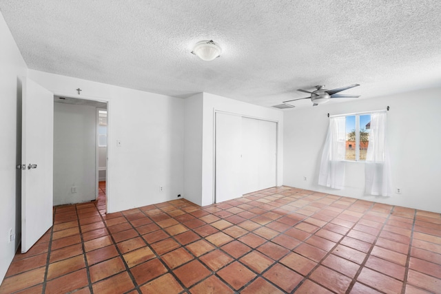 unfurnished room with a ceiling fan, a textured ceiling, and tile patterned floors