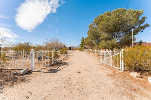 view of yard featuring a rural view, fence, and a gate