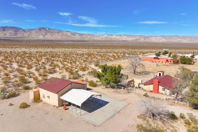drone / aerial view featuring a desert view and a mountain view