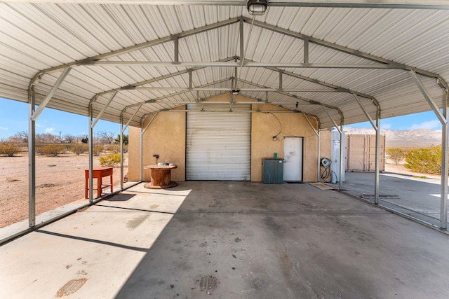 view of car parking featuring a mountain view and a carport