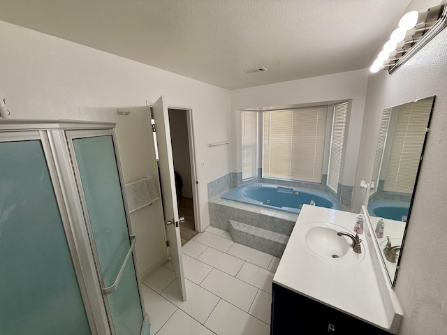 bathroom with a whirlpool tub, a textured ceiling, tile patterned flooring, and vanity