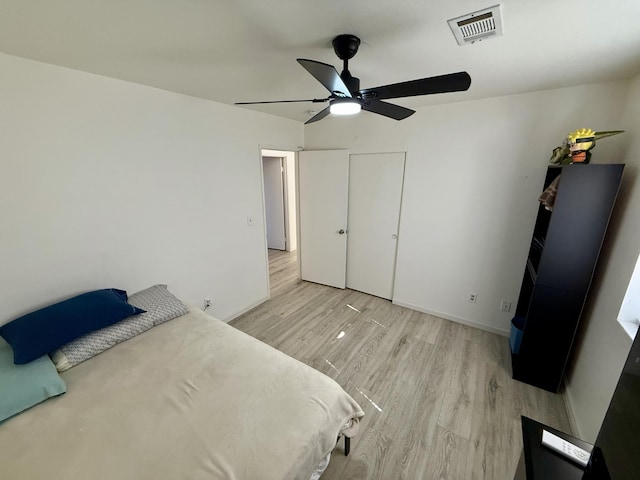 unfurnished bedroom with light wood-style flooring, a ceiling fan, visible vents, and baseboards