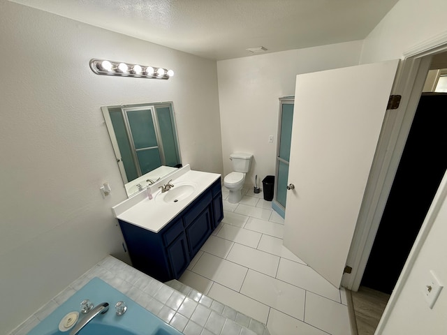 bathroom with visible vents, toilet, a bathing tub, vanity, and tile patterned flooring