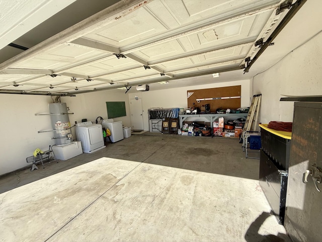 garage with a garage door opener, strapped water heater, and separate washer and dryer