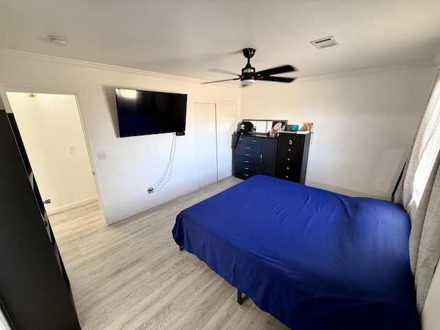 bedroom with visible vents, a ceiling fan, light wood-style flooring, crown molding, and a closet