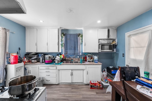 1411 W Ivesbrook St, Lancaster, CA 93534 - kitchen with white cabinets, light countertops, stainless steel microwave, and recessed lighting
