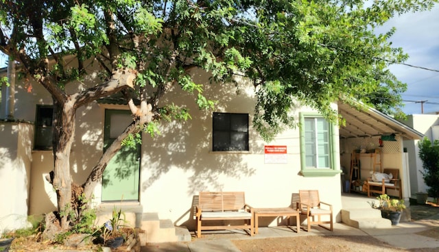 back of property with a patio area and stucco siding