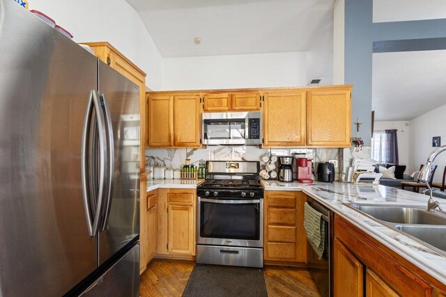 kitchen with light countertops, dark wood-style flooring, appliances with stainless steel finishes, and a sink